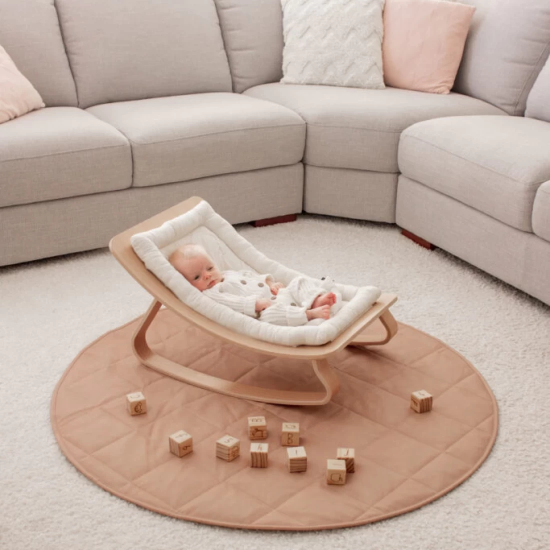 Baby rocking chair and wooden cube toy placed on the Henlee Quilted best baby play mat.