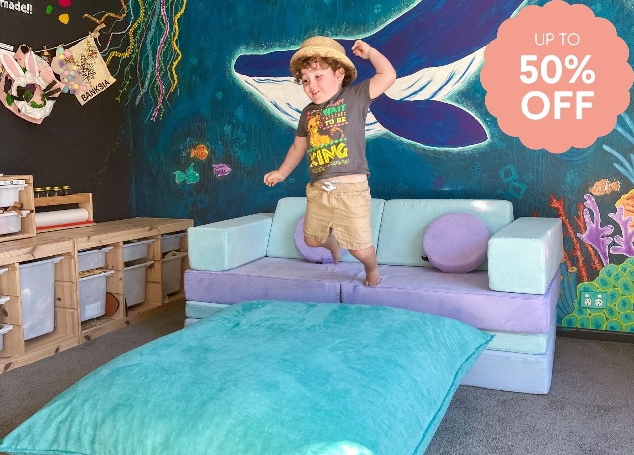 a toddler jumping on a funsquare play pillow