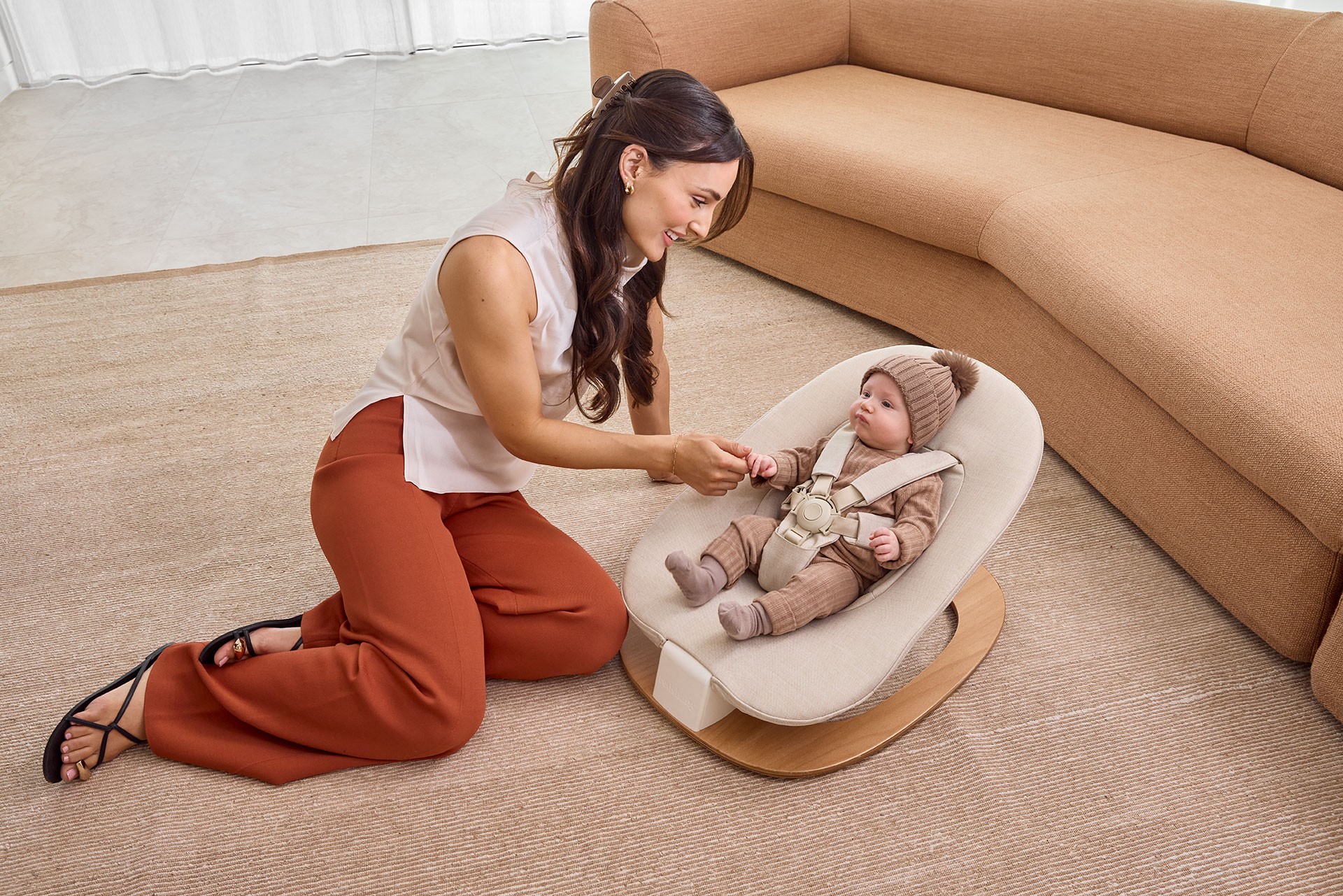 Mum bonding with her infant in a newborn baby bouncer, perfect for safe playtime at home.