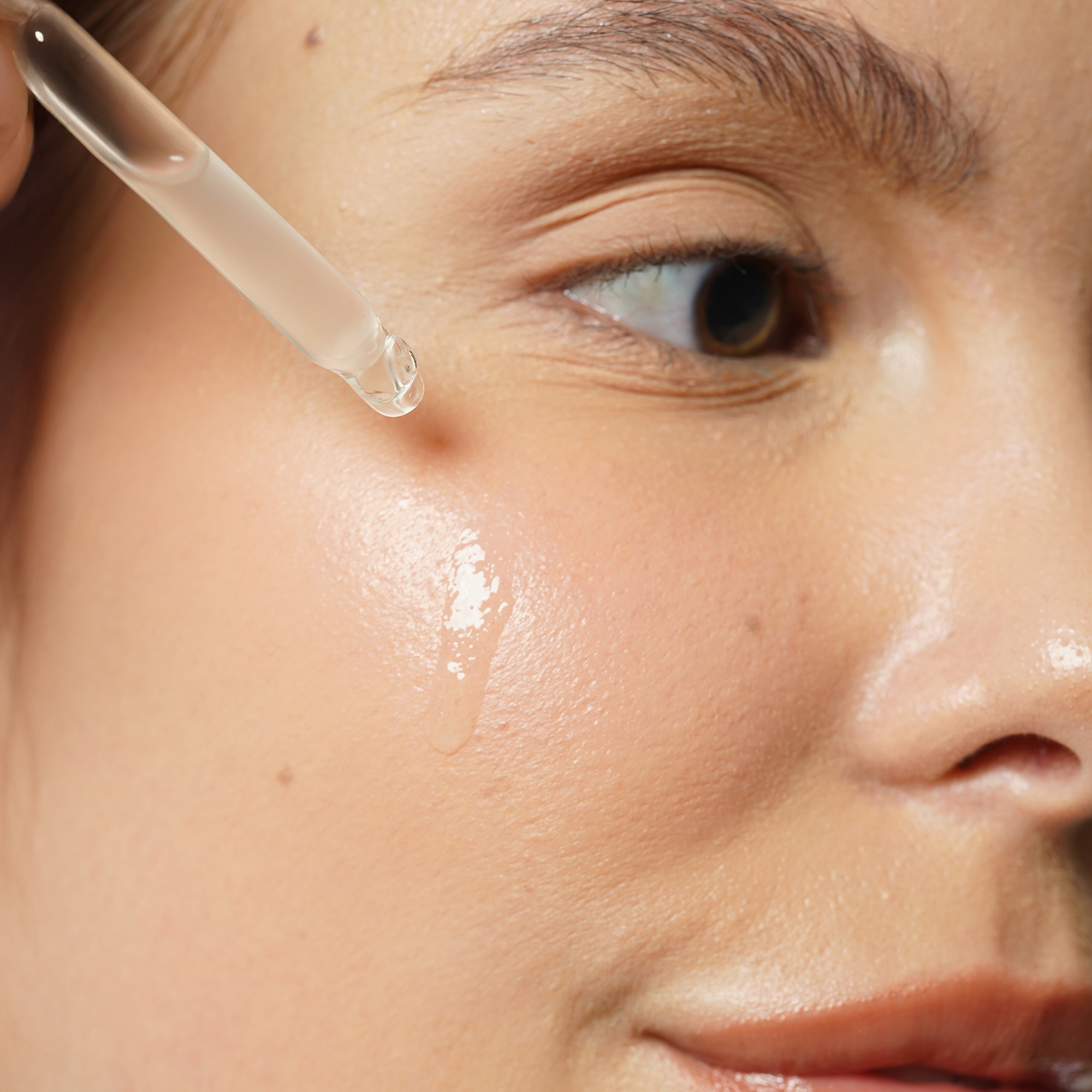 Pregnant woman using facial serum to achieve smooth, glowing skin – an essential step in pregnancy safe skincare.