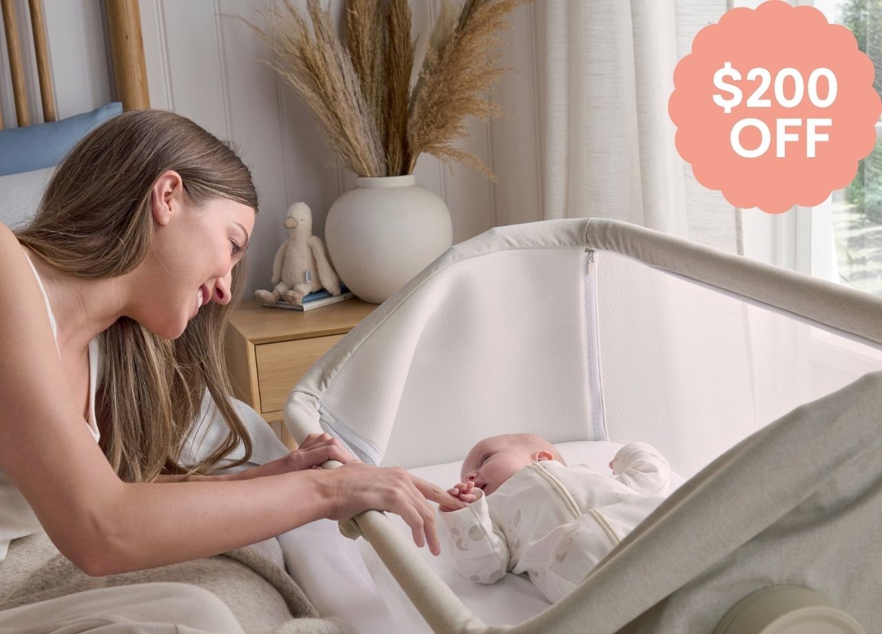 A mum soothing her baby in a bassinet