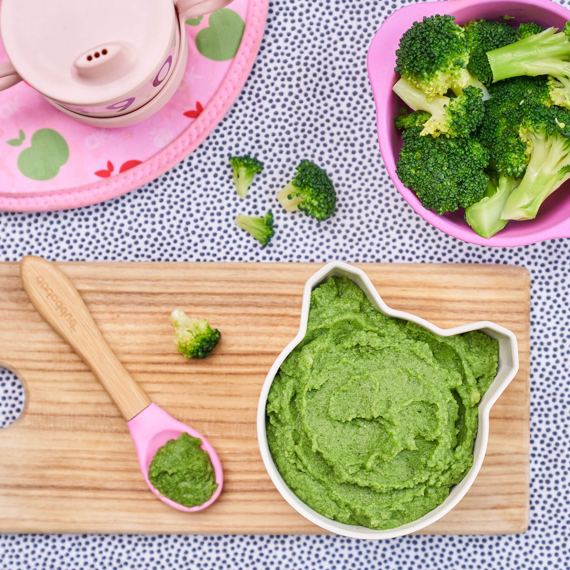 Close-up of silicone bowl filled with broccoli florets and puree, illustrating a baby led weaning approach.