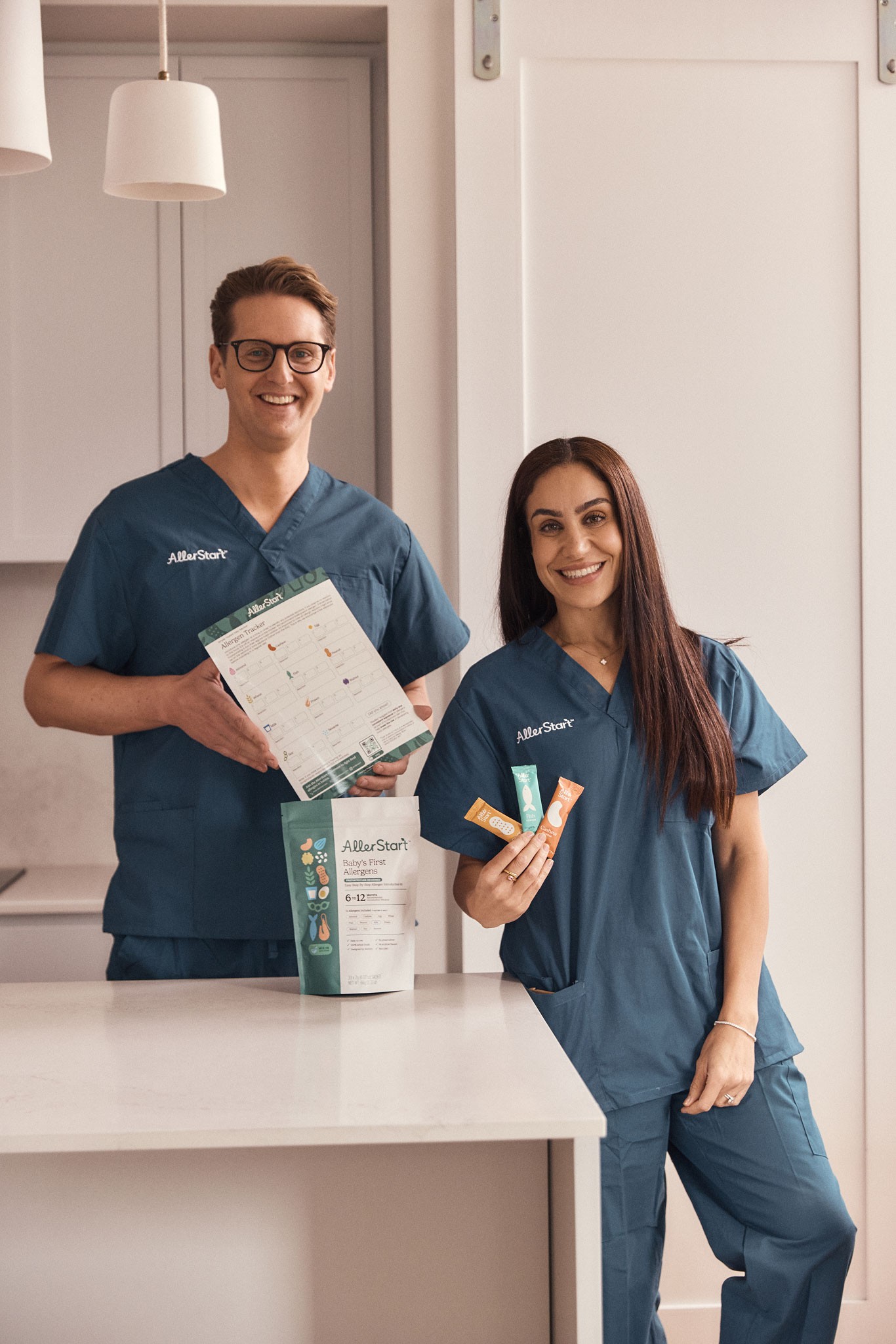 Dr Rob a paediatrician and the co-creator of AllerStart holding packs of Allerstart products showing how to introduce allergens to baby