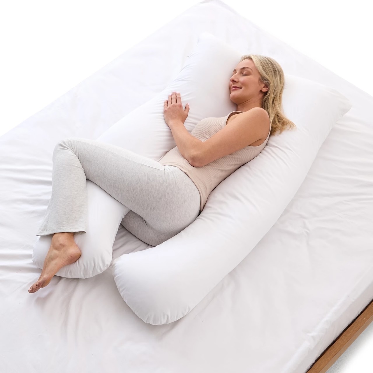 Woman lying down on her Kmart Pregnancy Pillow