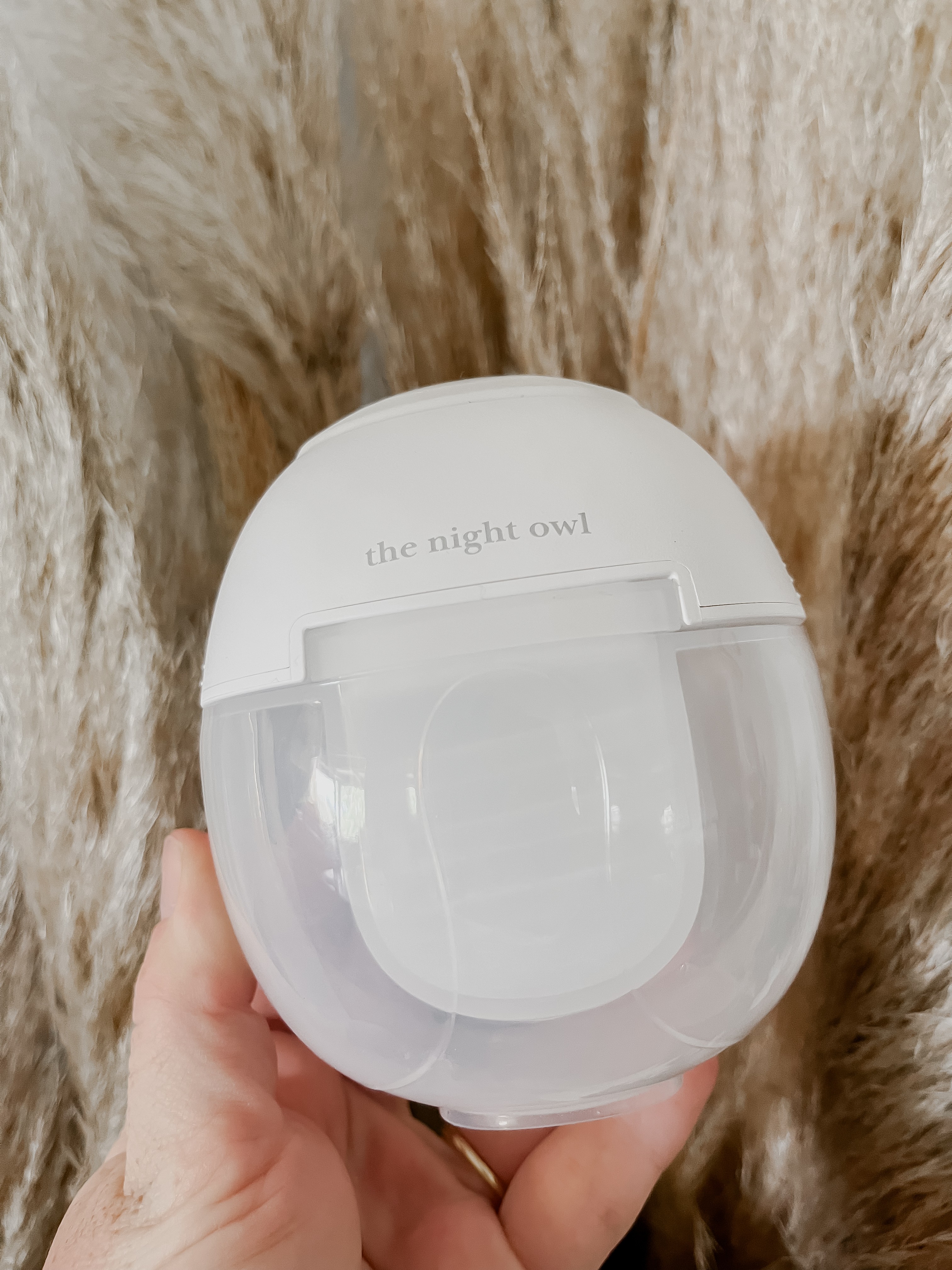 Mum holding the Night Owl Mumma Owl wearable Breast pump designed for comfort and hands-free pumping.