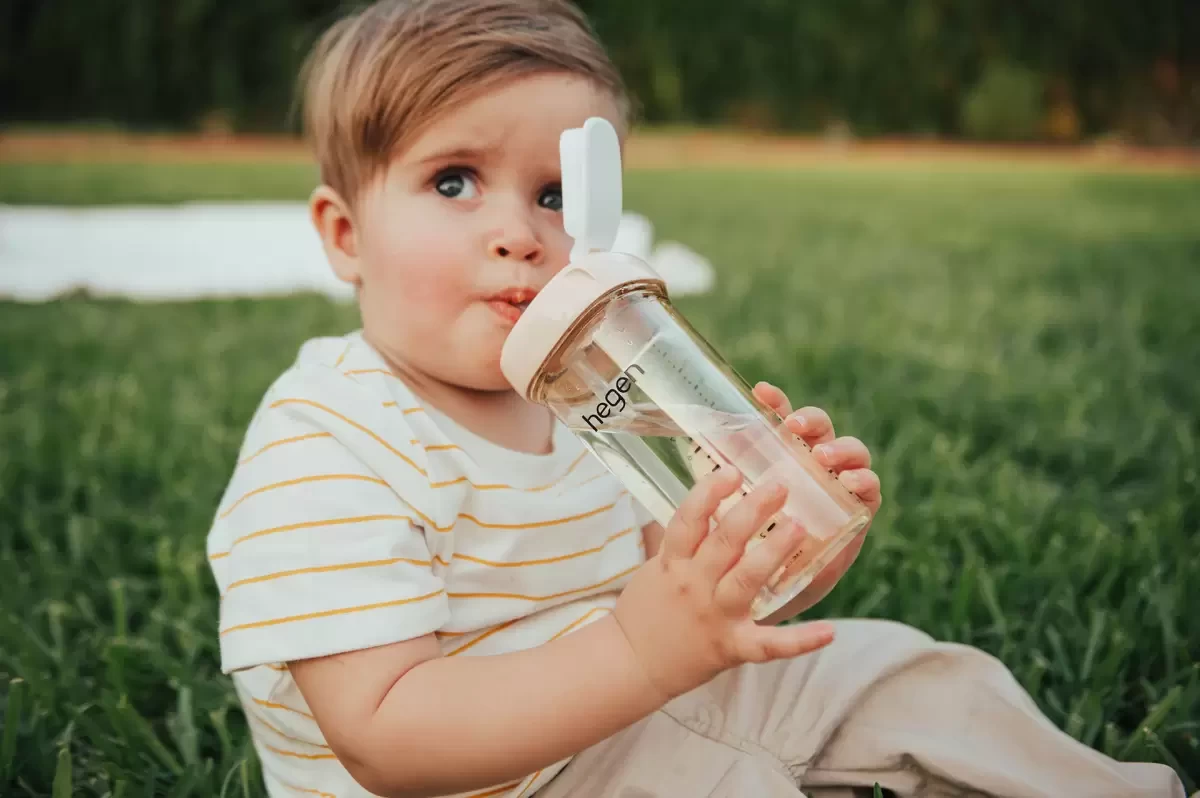 A toddler using a straw cup