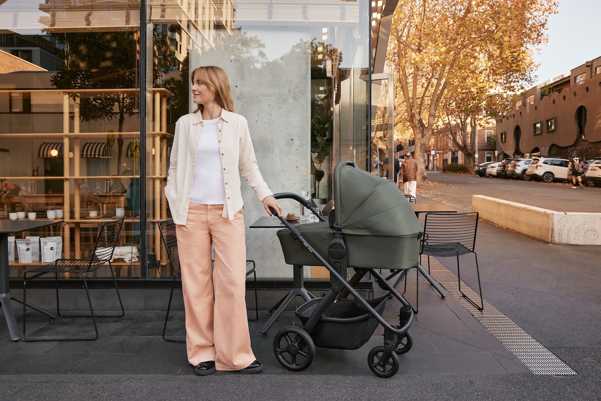 An Australian mum standing in front of a store with her Milly + Coup pram