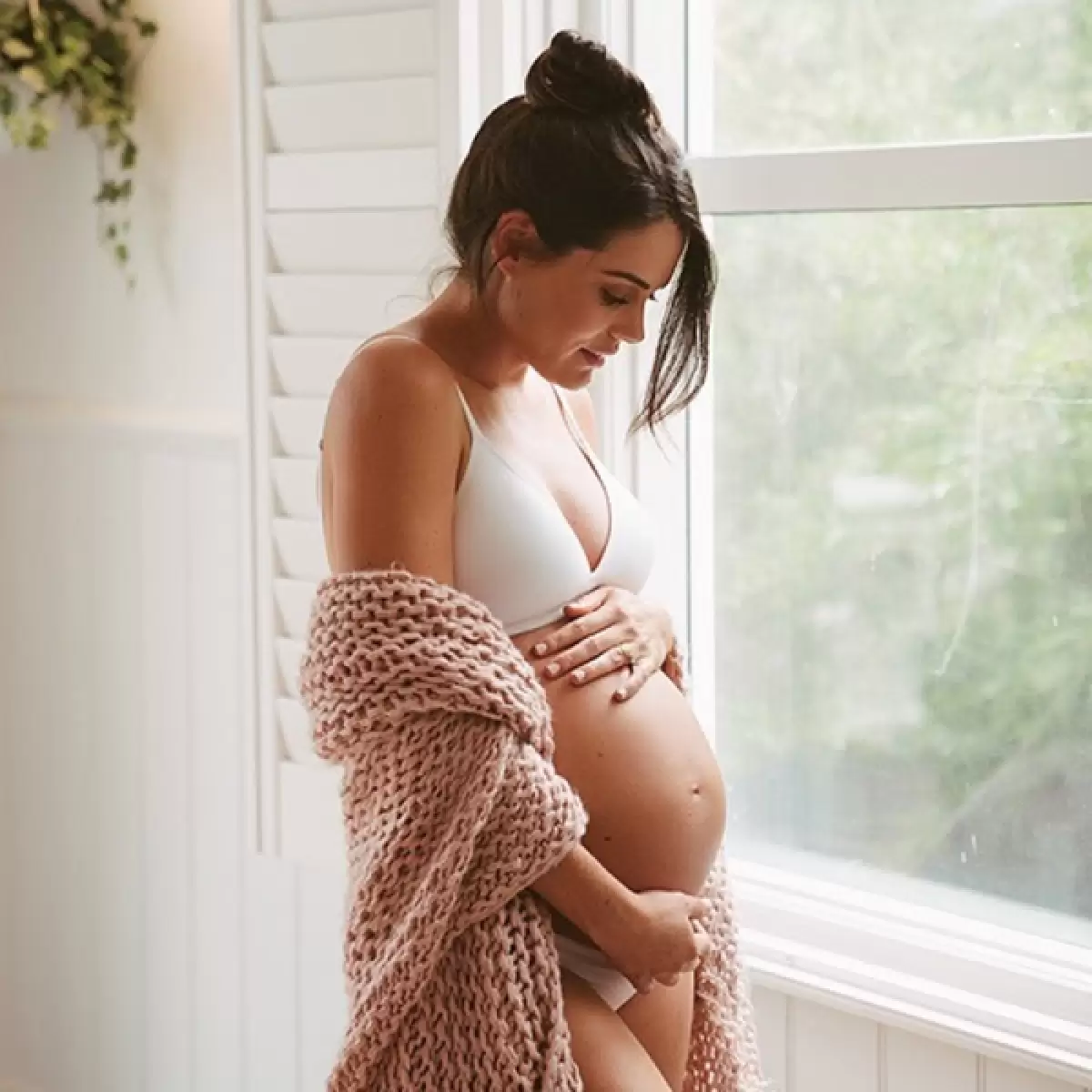 Mum holding her baby bump, illustrating common skin changes when pregnant