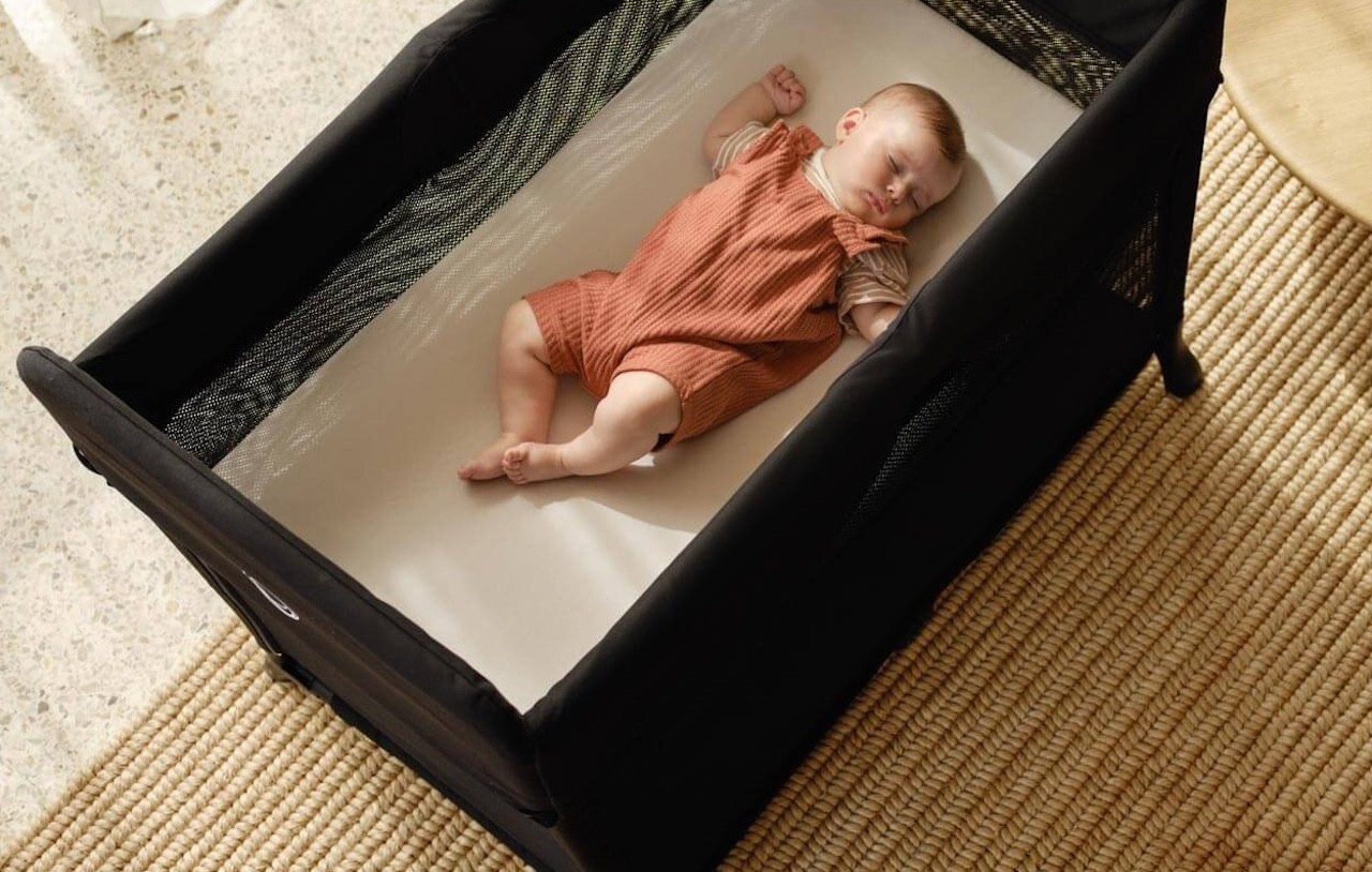 The Bugaboo Stardust Plus portacot with a baby in it in the bassinet position