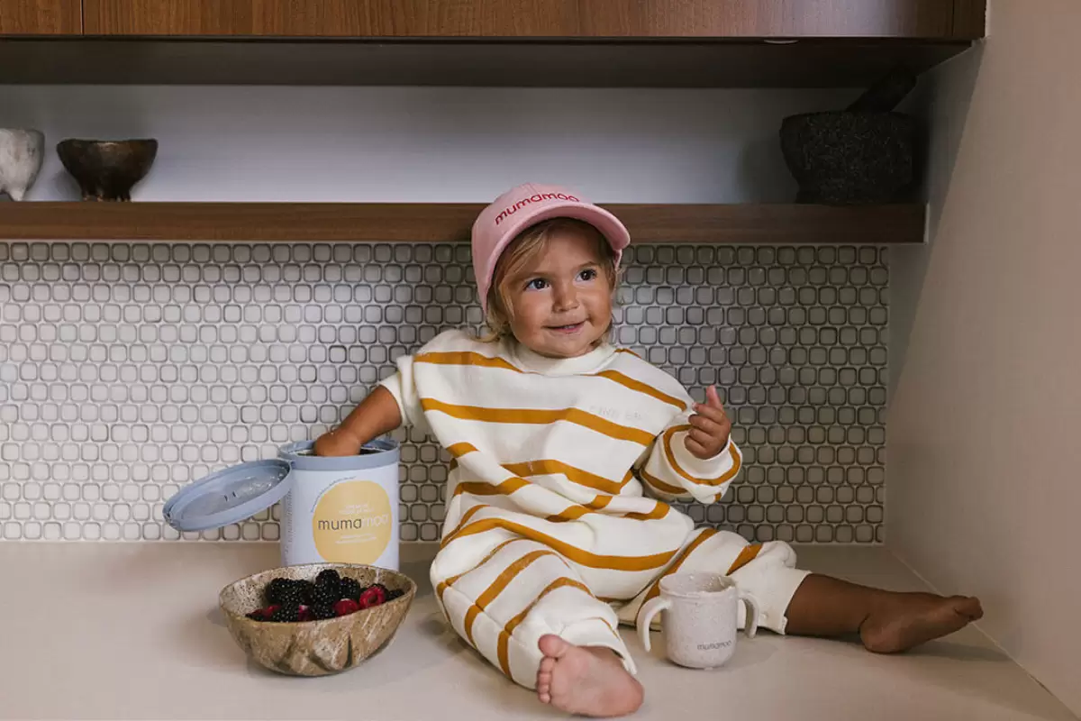 Toddler seated on a countertop reaching for the best formula milk in Australia - trusted premium nutrition for kids