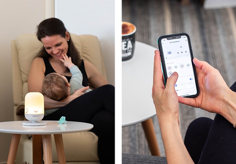Mum holding her baby beside a table with TweetyDreams best white noise machine, while a hand holds a phone showing the TweetyDreams app