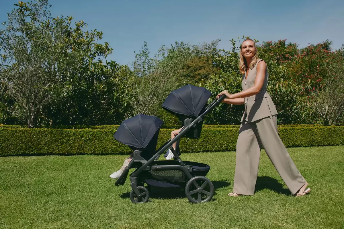 A woman walking her baby in a pram in australia