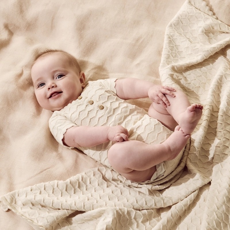 the wilson and frenchy organic baby bodysuit on a baby