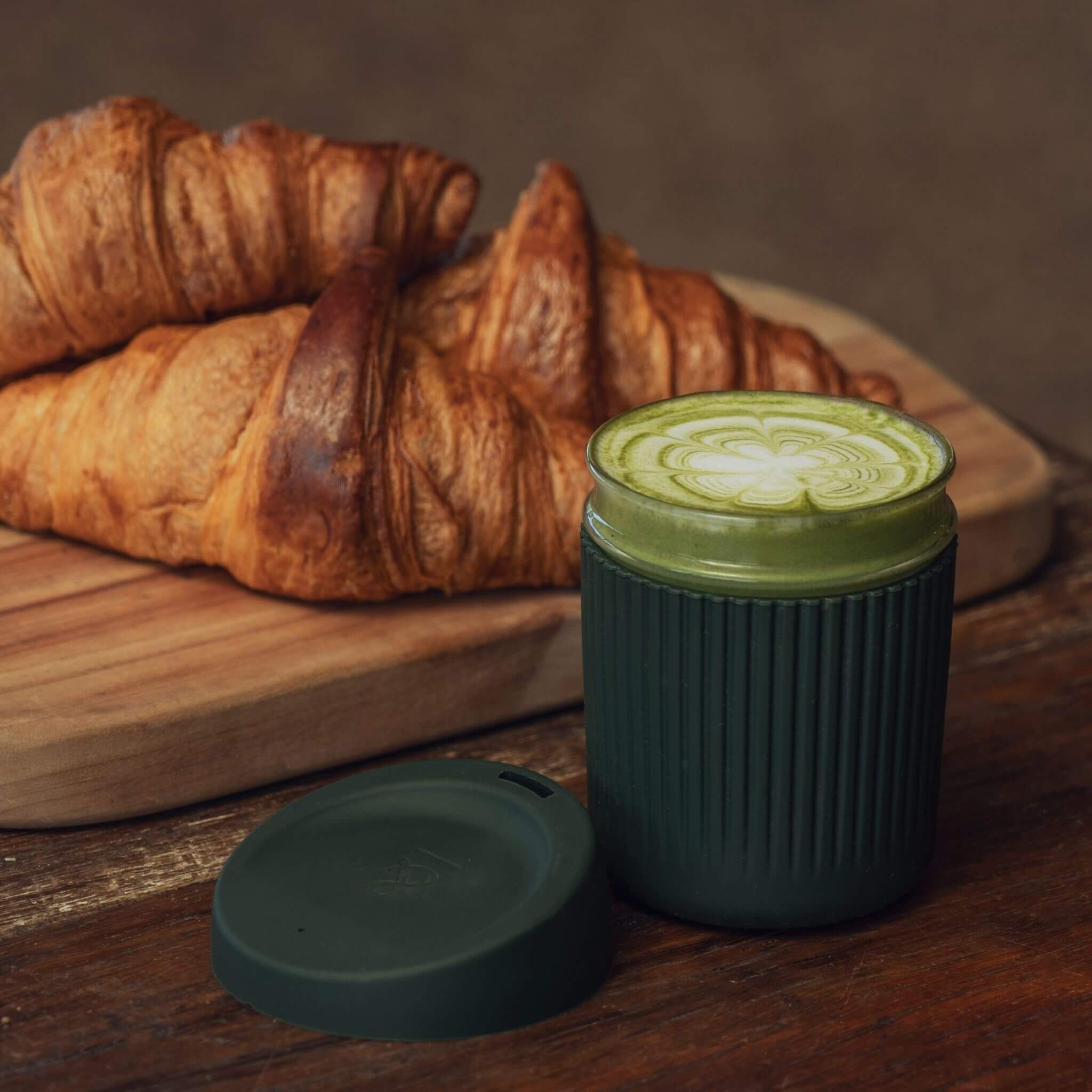 the seed & sprout coffee cup next to croissants