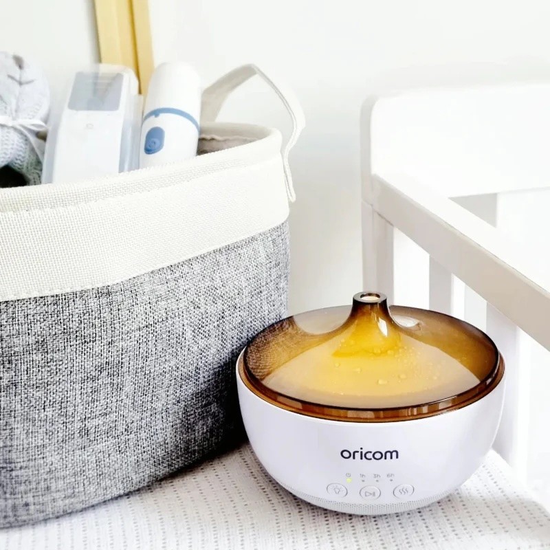 Oricom's baby humidifier shown in a nursery setting with the yellow light on