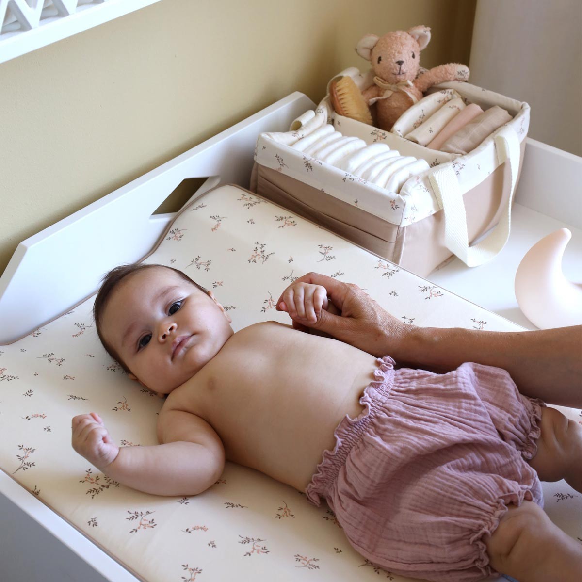 Baby girl on changing table with Danish by Design diaper caddy Australia packed with nappies for a quick nappy change.