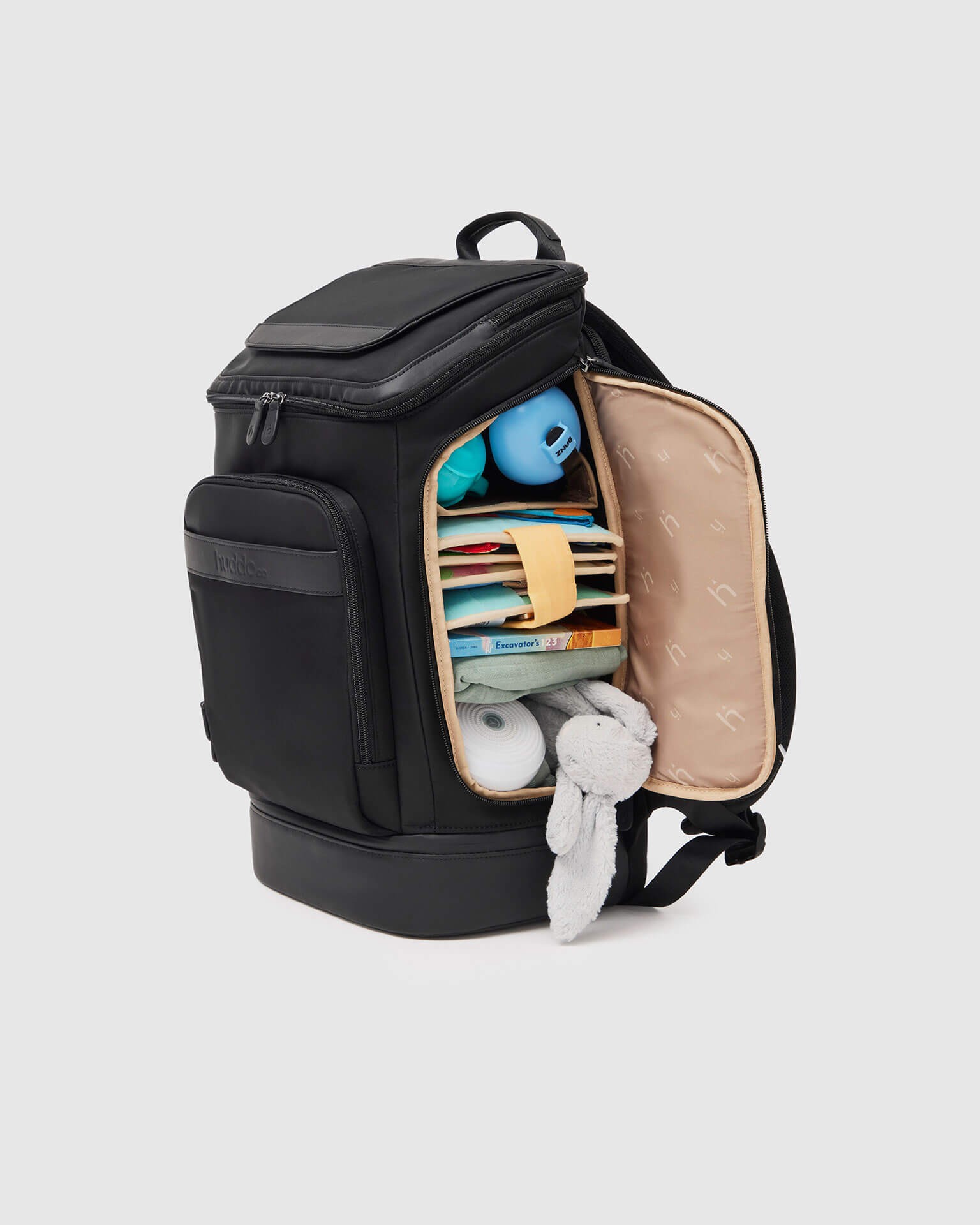 HuddoCo Baby Travel Backpack with side zip open, neatly packed with baby products for travel convenience.