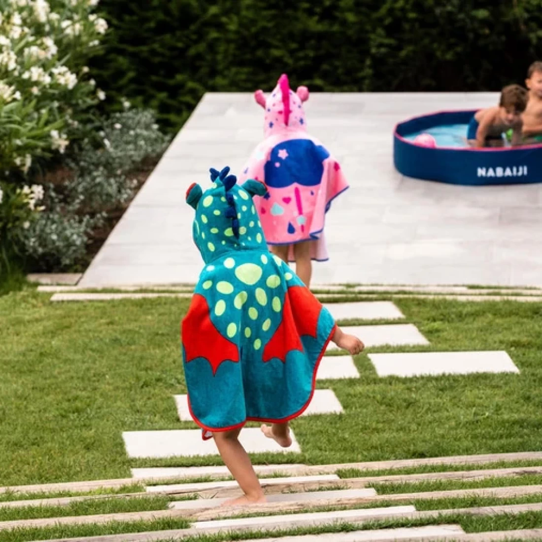 Happy child going down the stairs wearing the best hooded beach towel