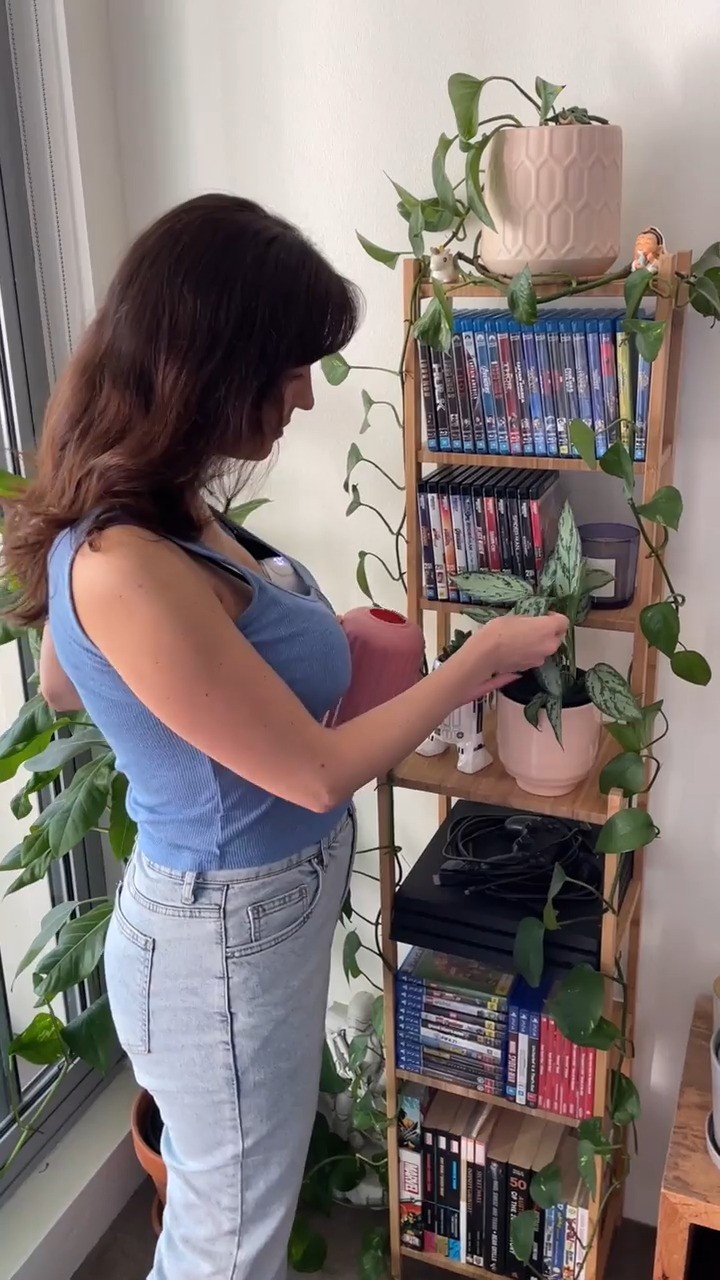 Woman comfortably wearing the Night Owl Mumma Owl wearable Breast pump while tending to her plants.