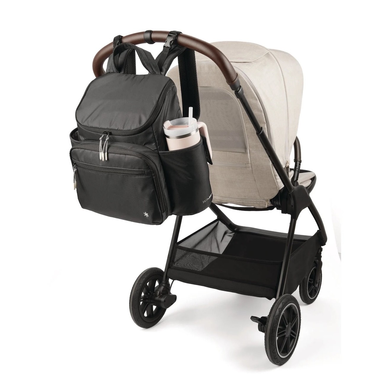 The Skip Hop Nappy Backpack shown hanging on the back of a pram