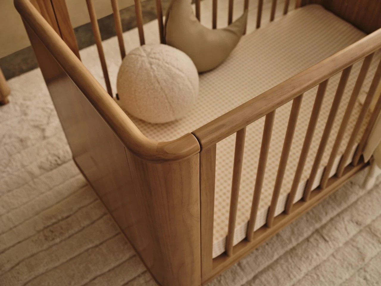 A close up of the Seena Willow cot showing the curved corner and minimalist design