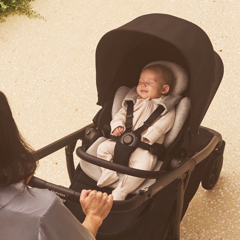 A baby smiling while lying in the Babybee Alto pram in australia