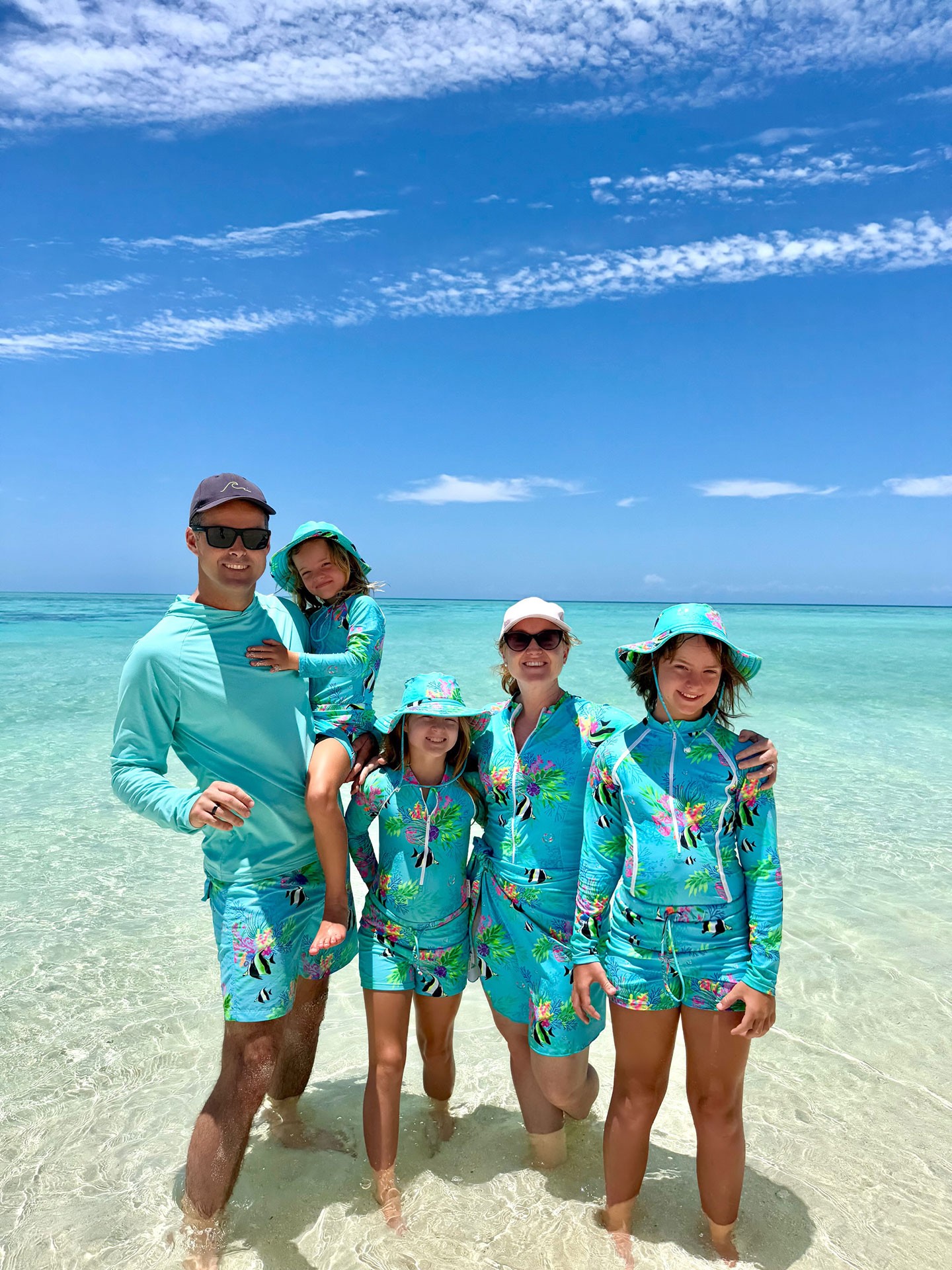 Parents and kids dressed in matching family swimwear for a fun day by the ocean in Australia.
