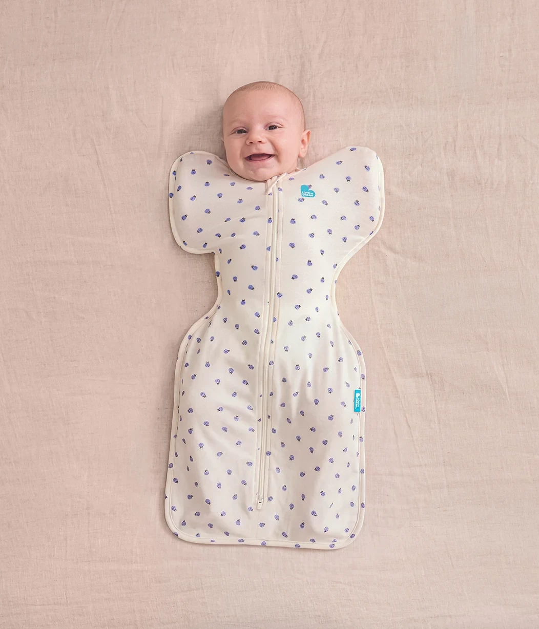 A baby in an arms up swaddle, one of the best summer sleeping bags for babies in australia
