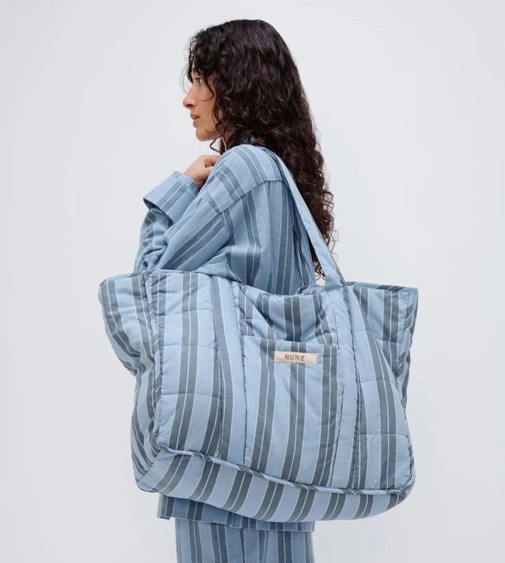 A woman wearing a striped shirt and the Nune tote bag