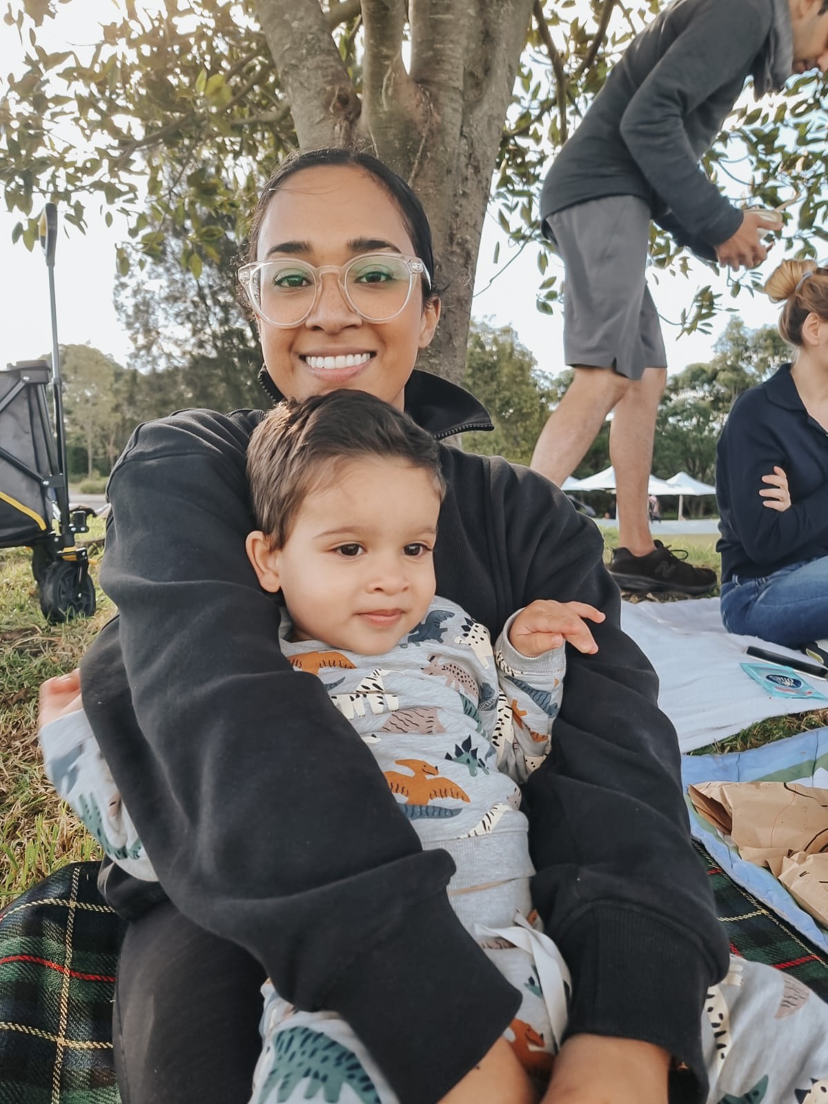 Joyful mum holding her little boy at the park, featured in How to Raise a Boy The Boys Parents' Guide.