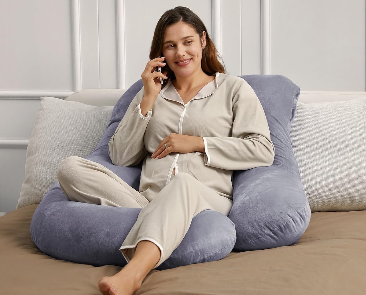 Woman sitting on her Momcozy pregnancy pillow