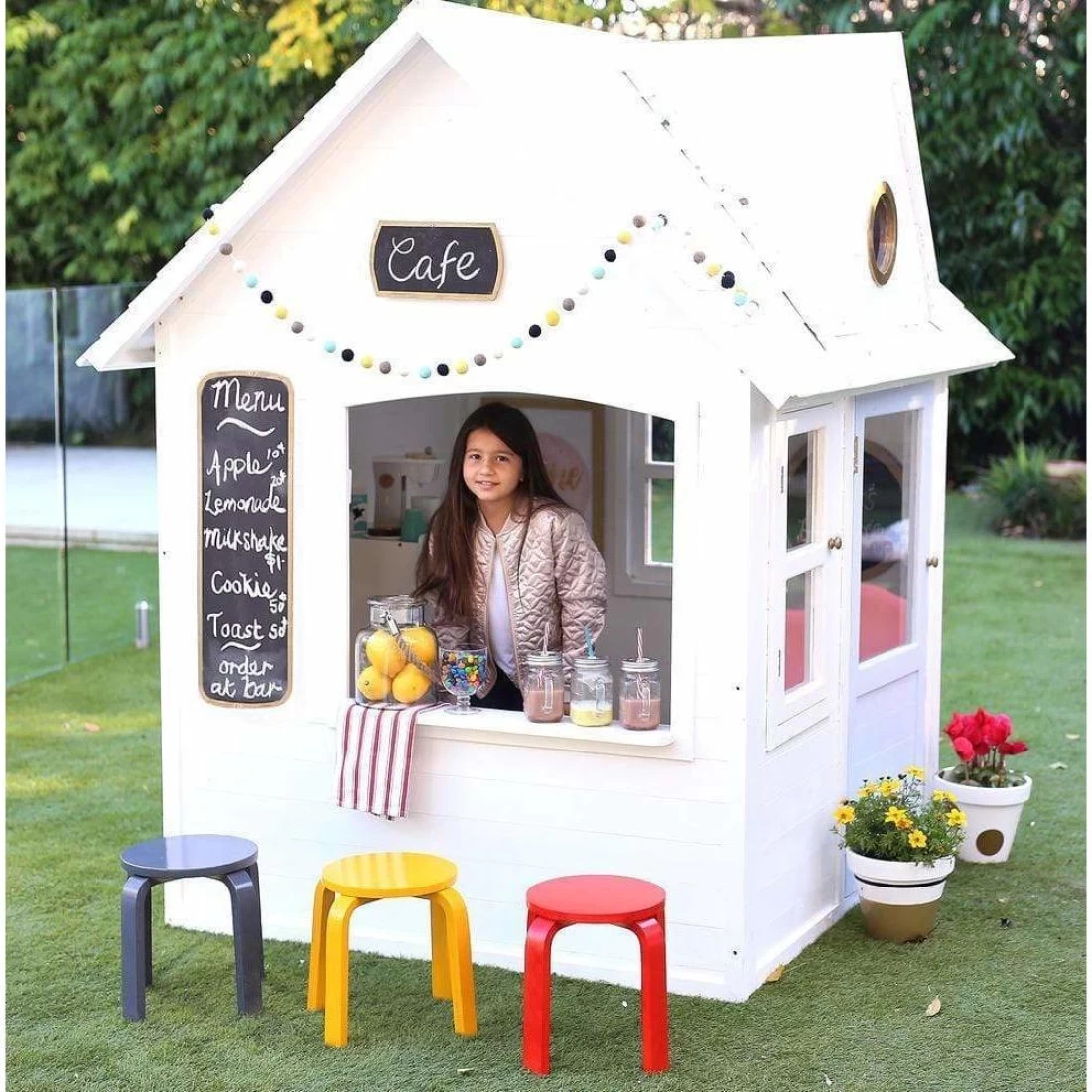 Girl playing inside one of the best cubby houses for kids.