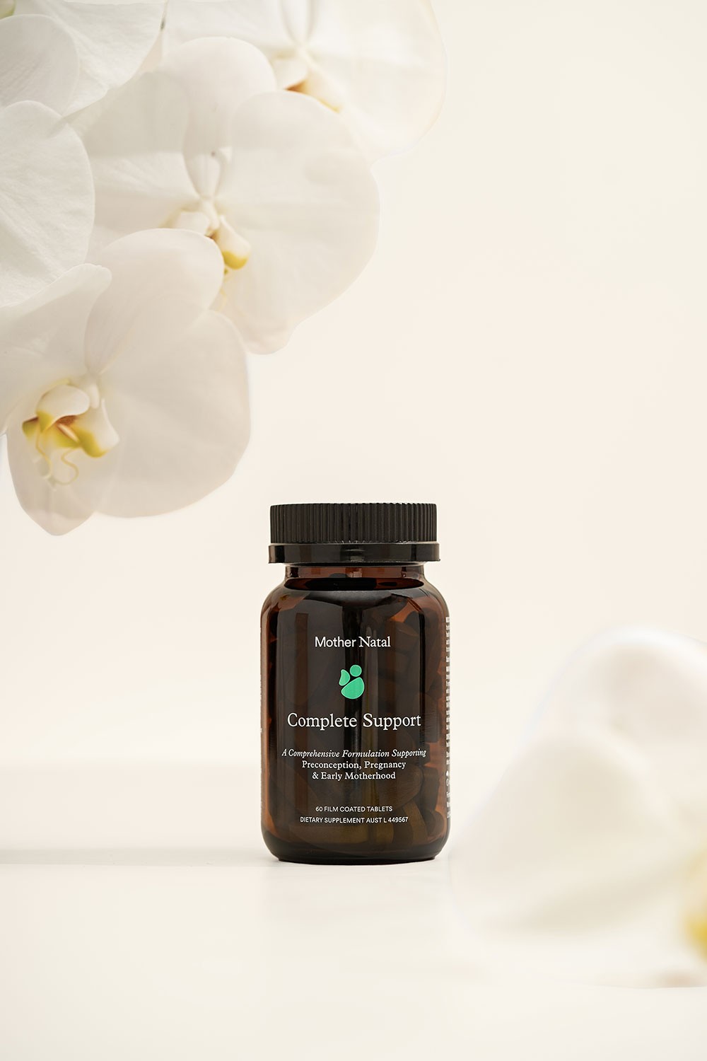 Mother Natal pregnancy supplement vitamins displayed with elegant white orchid