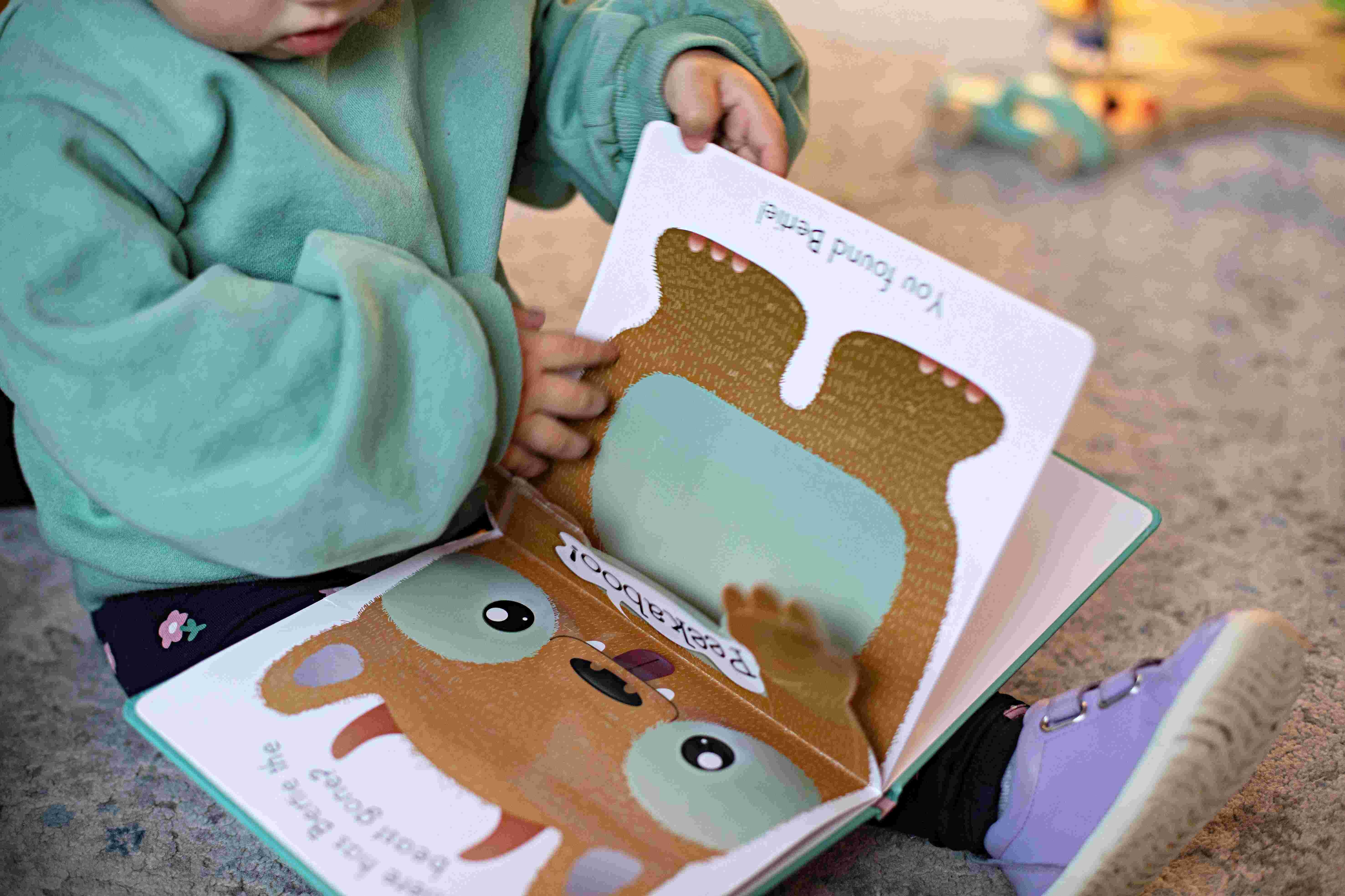 Toddler looking at a book during story time at one of the best childcare and daycare centres.