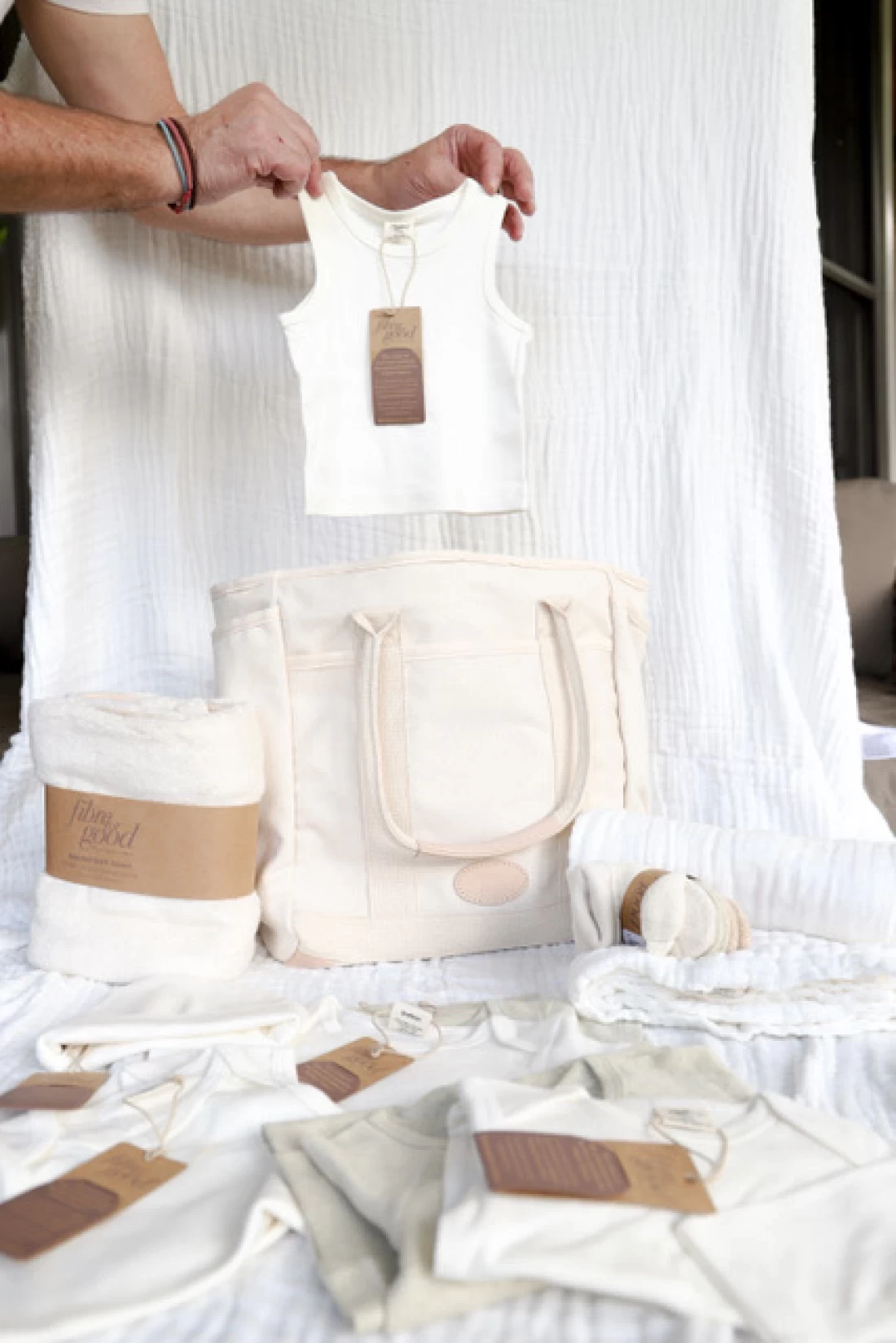 Eco friendly baby clothing and reusable tote bag displayed together, representing the best eco friendly baby product gift set