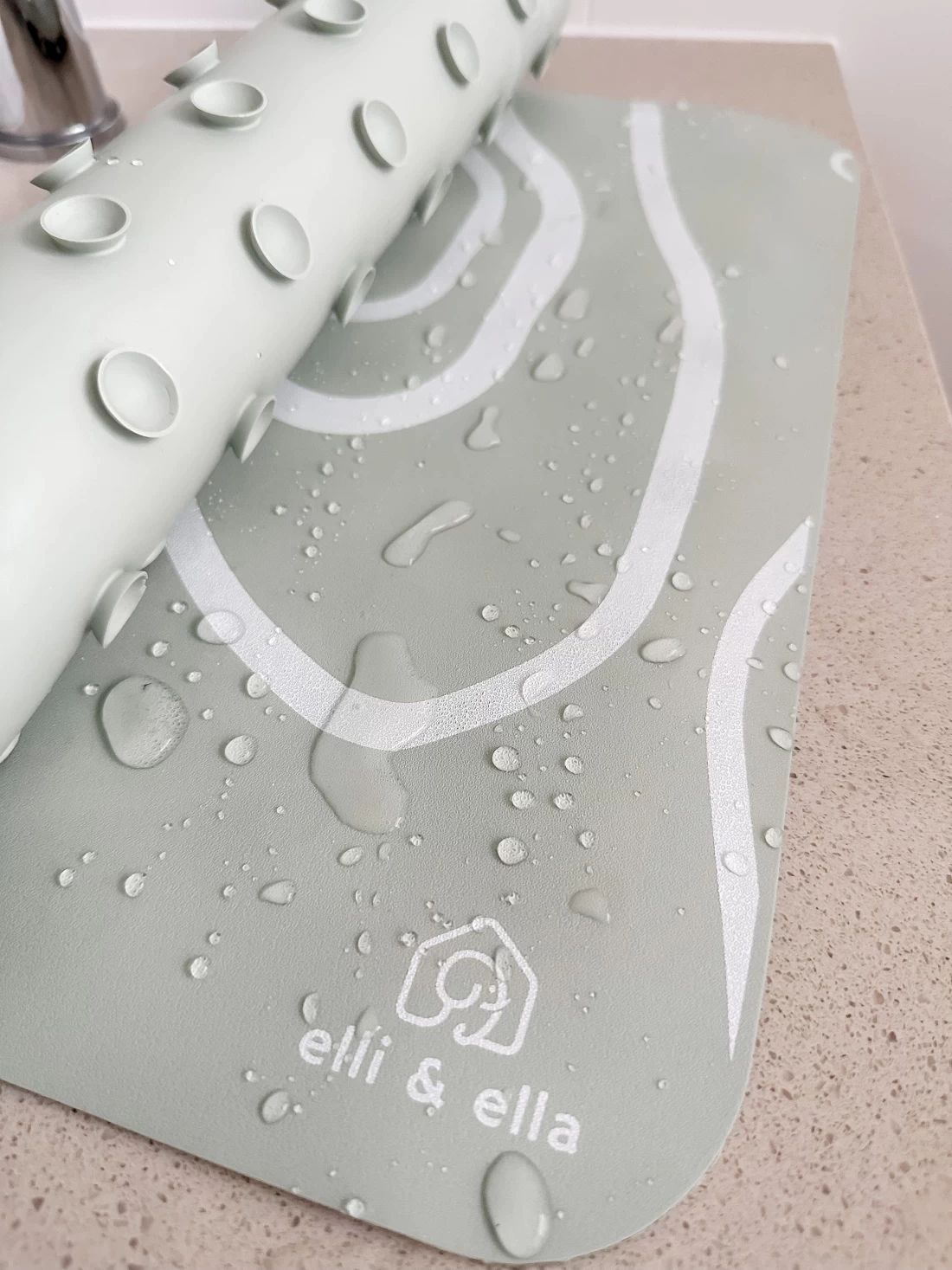 Half-rolled best bath mat with visible water drops, showing absorbent texture and quick-dry design.