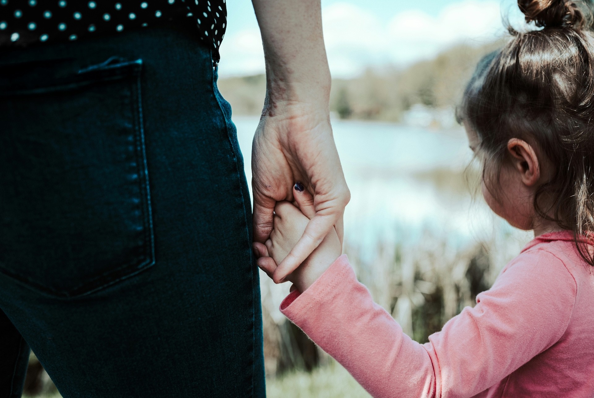 An Australian mum holding her toddler's hand