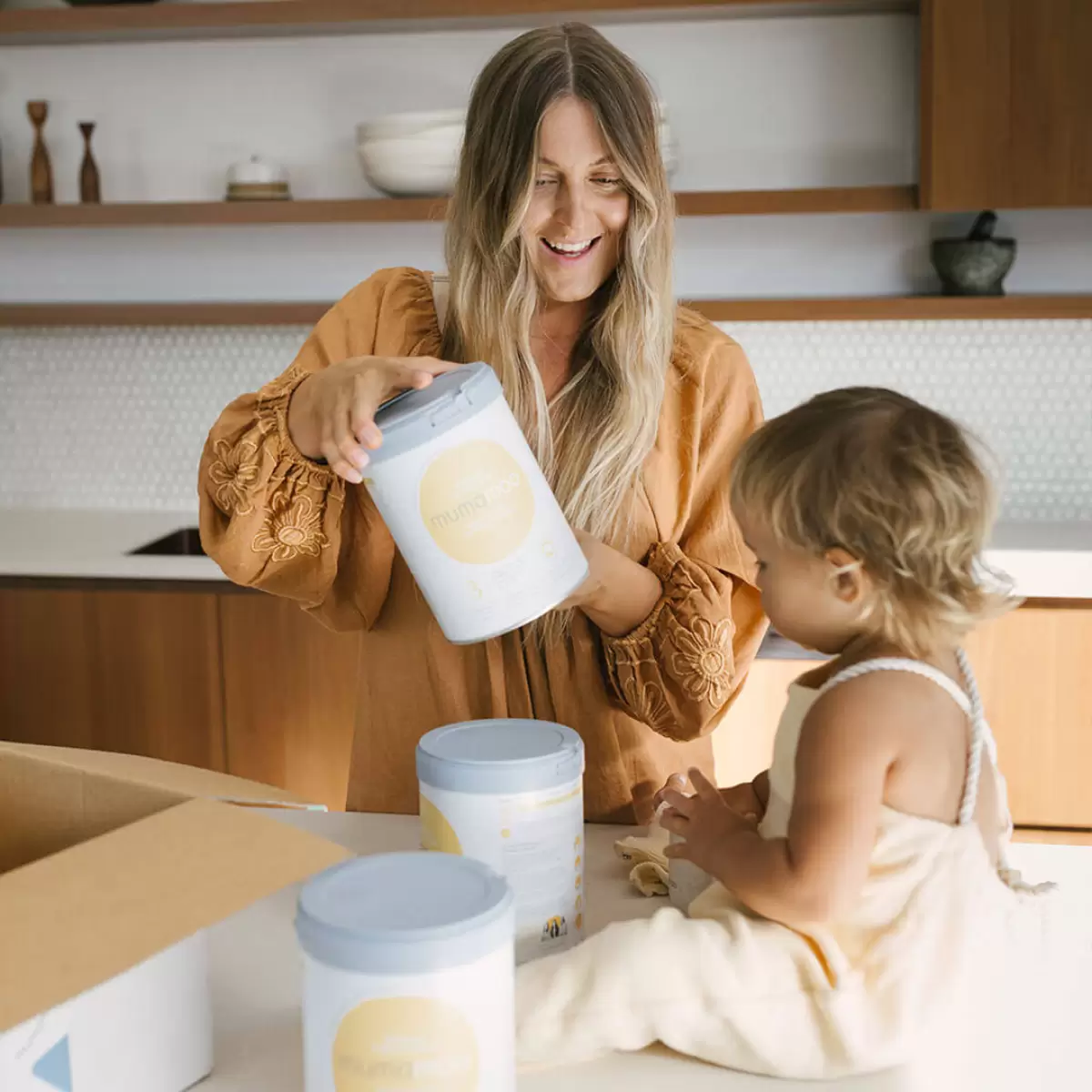Happy mama holding a can of toddler formula mumamoo - premium and nutritious toddler milk option