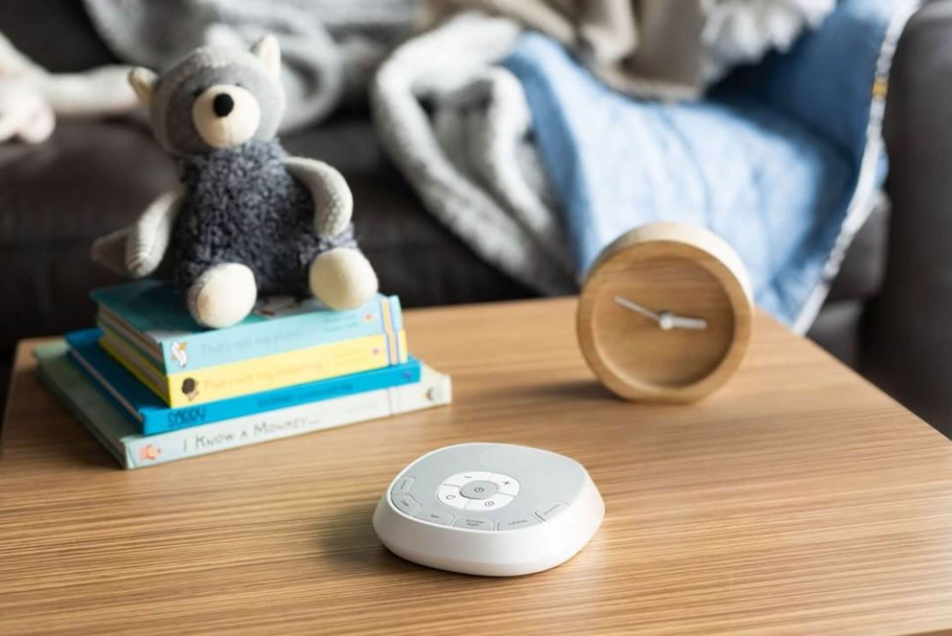 Baby sleep sound machine from Welcare displayed on wooden table with toys and books – perfect for peaceful sleep environments.