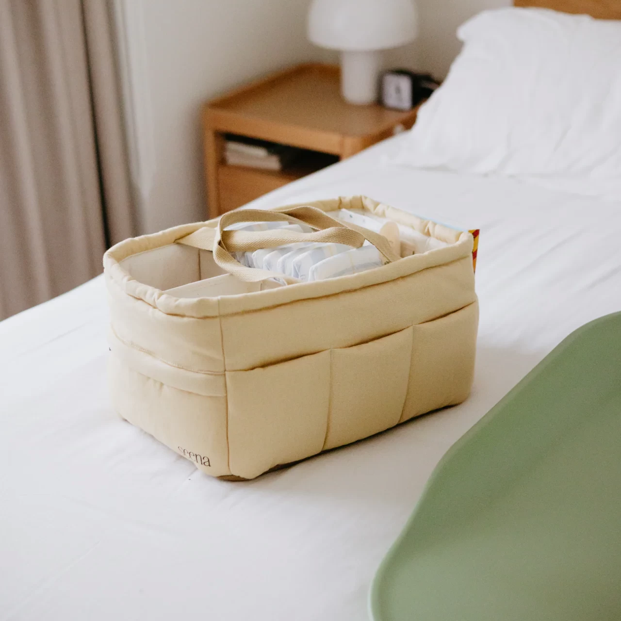 The Seena Migo Nappy Caddy sitting on a white bed