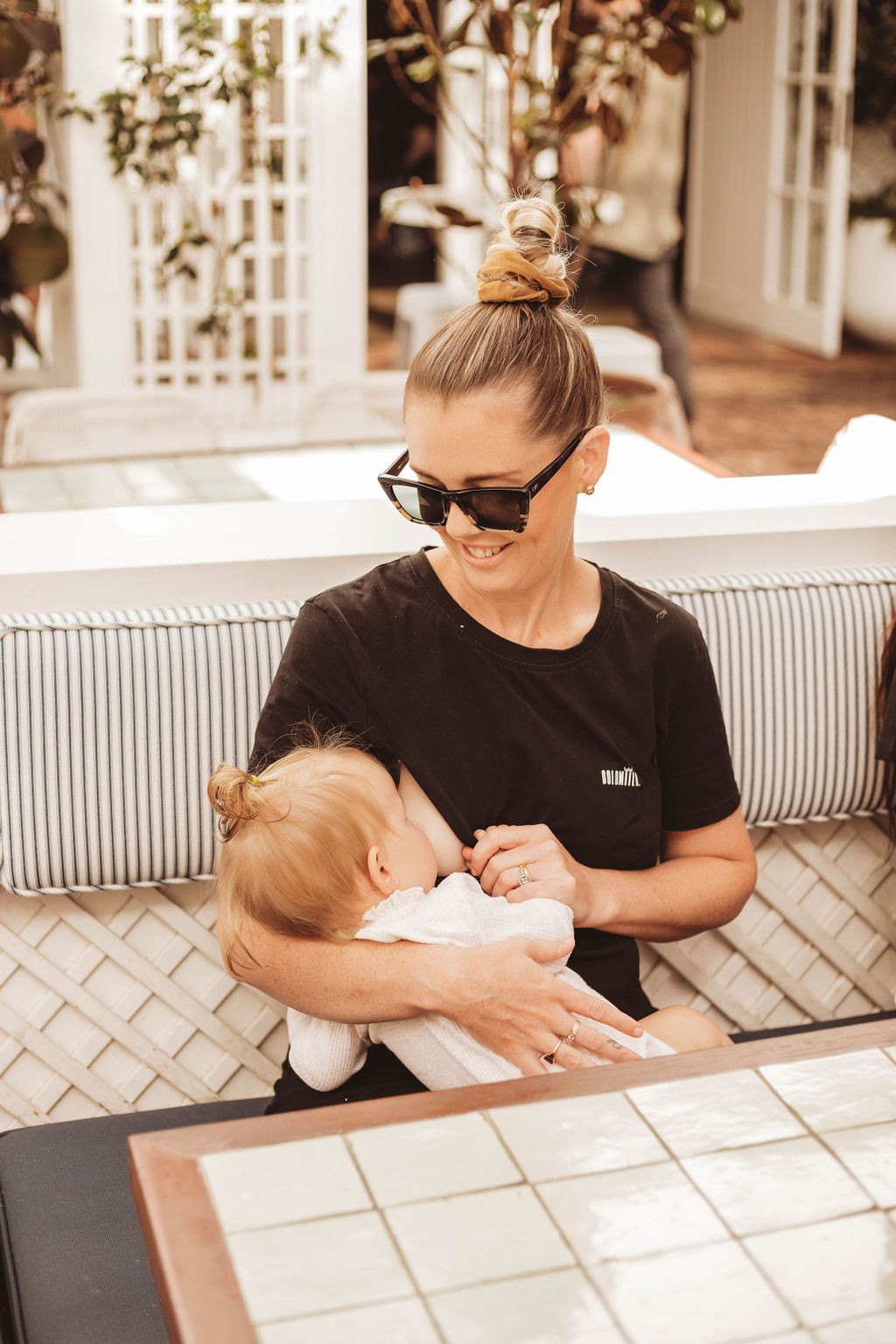 Mum breastfeeding her baby in comfort while wearing the best breastfeeding clothes.