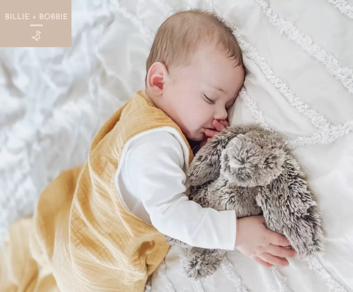 a baby asleep in a sleeping bag