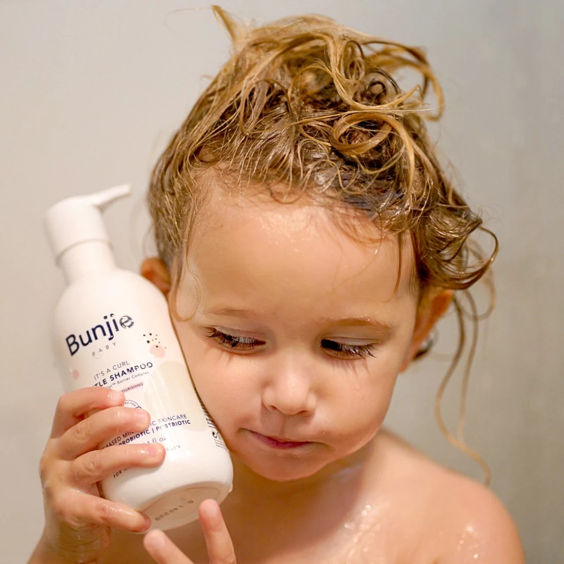 Newly bathed baby holding Bunjie Baby Skincare, the best eczema cream for babies for gentle skin care.