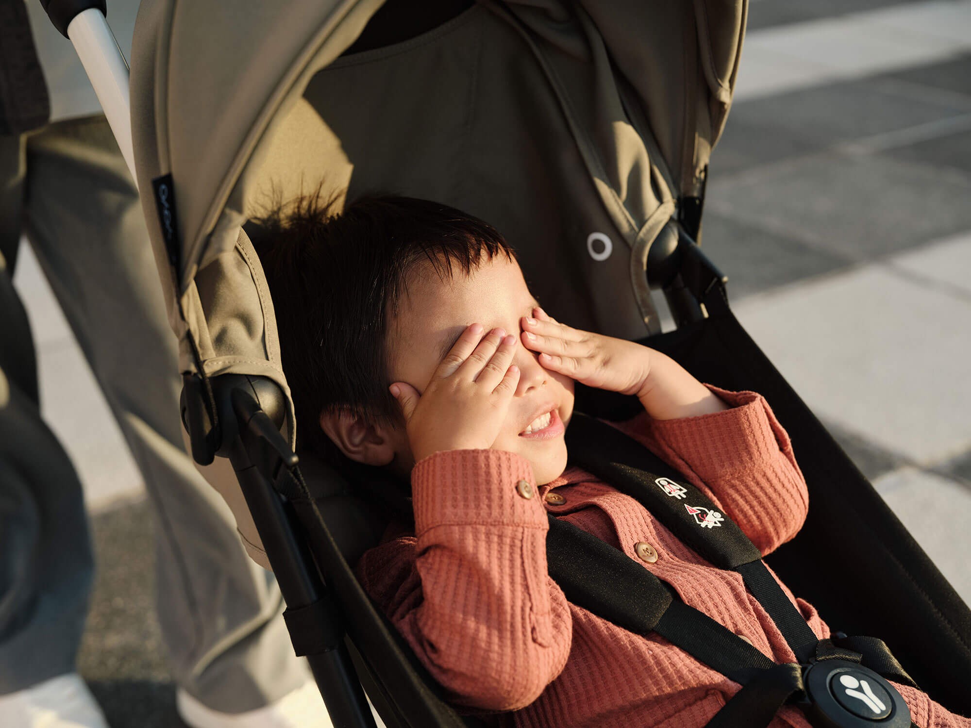 Closer look at the Stokke Yoyo³ Travel Pram with open canopy shading a child’s eyes