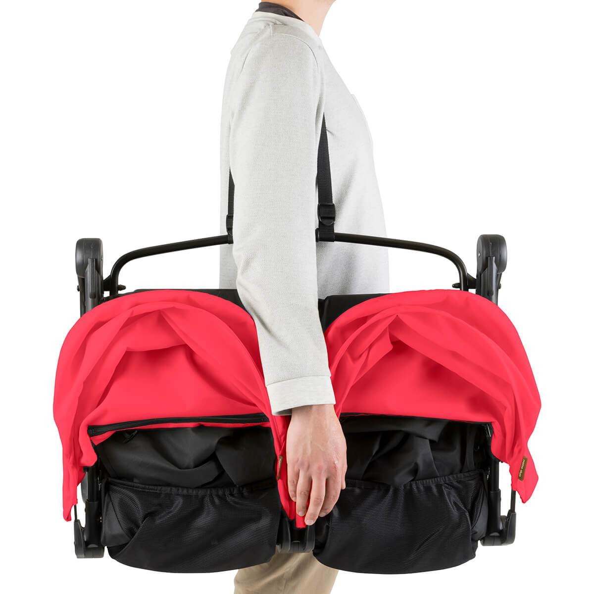 A man holding the folded down Mountain Buggy Nano Duo travel pram
