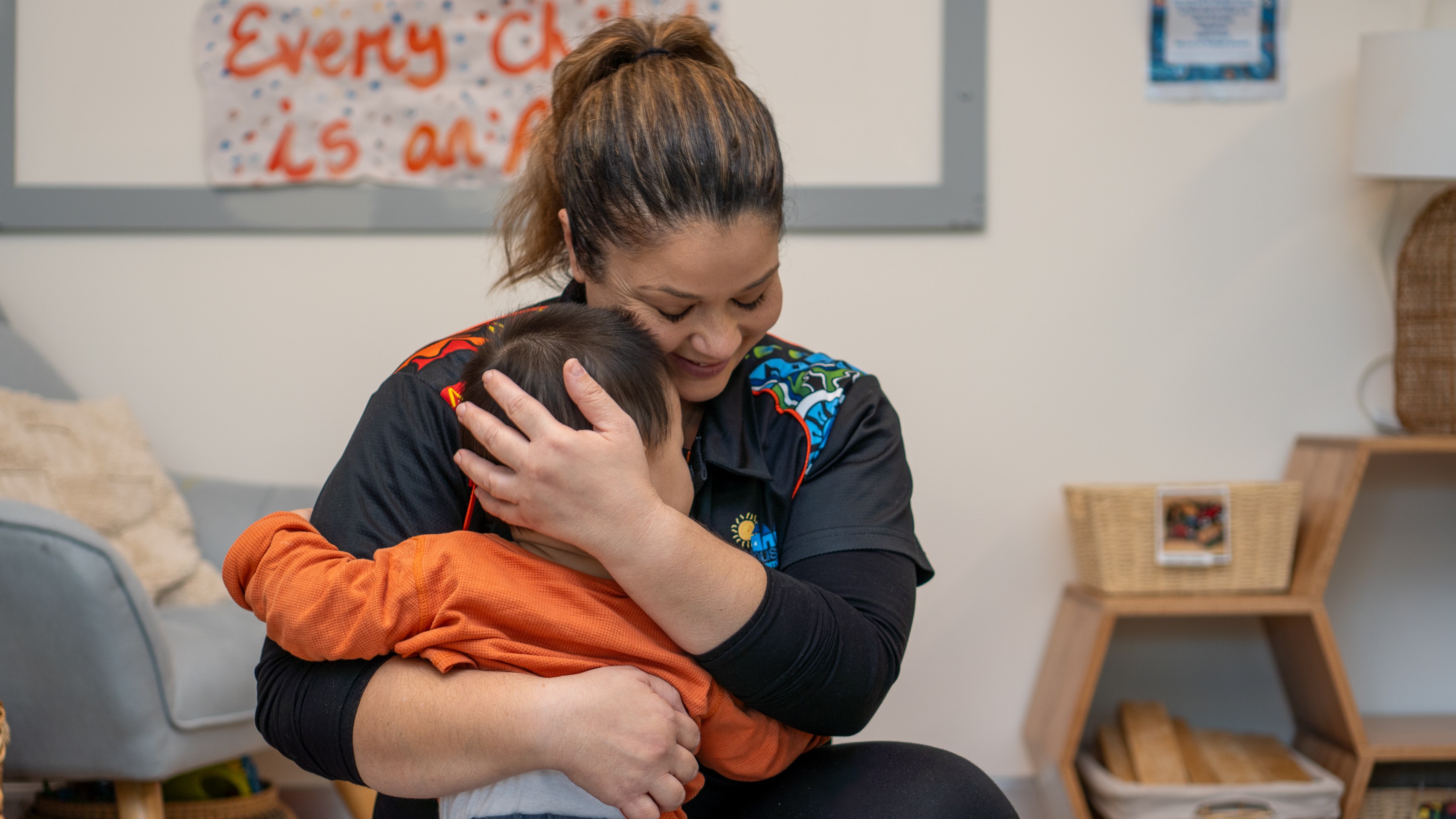 Educator hugging a toddler with care and warmth at the best childcare service