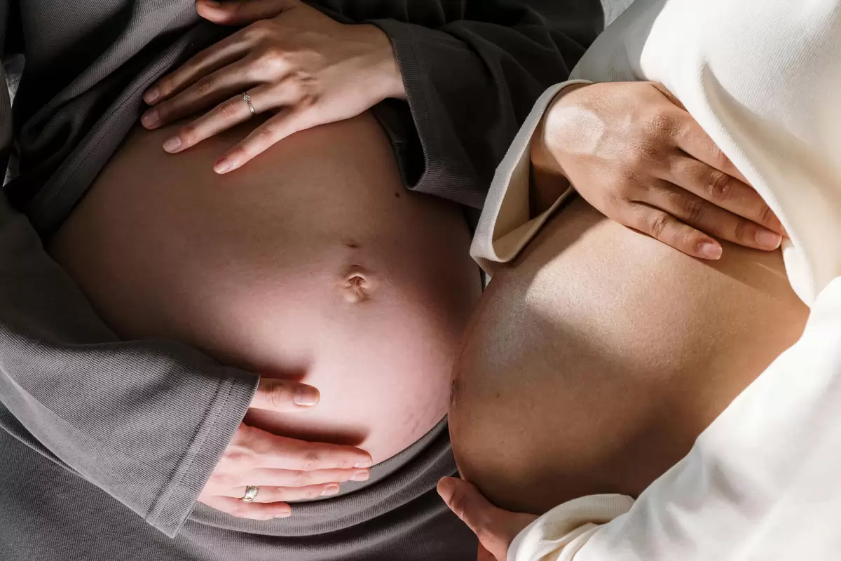 Expecting mums holding their belly bumps in late pregnancy – preparing for the stages of labour.