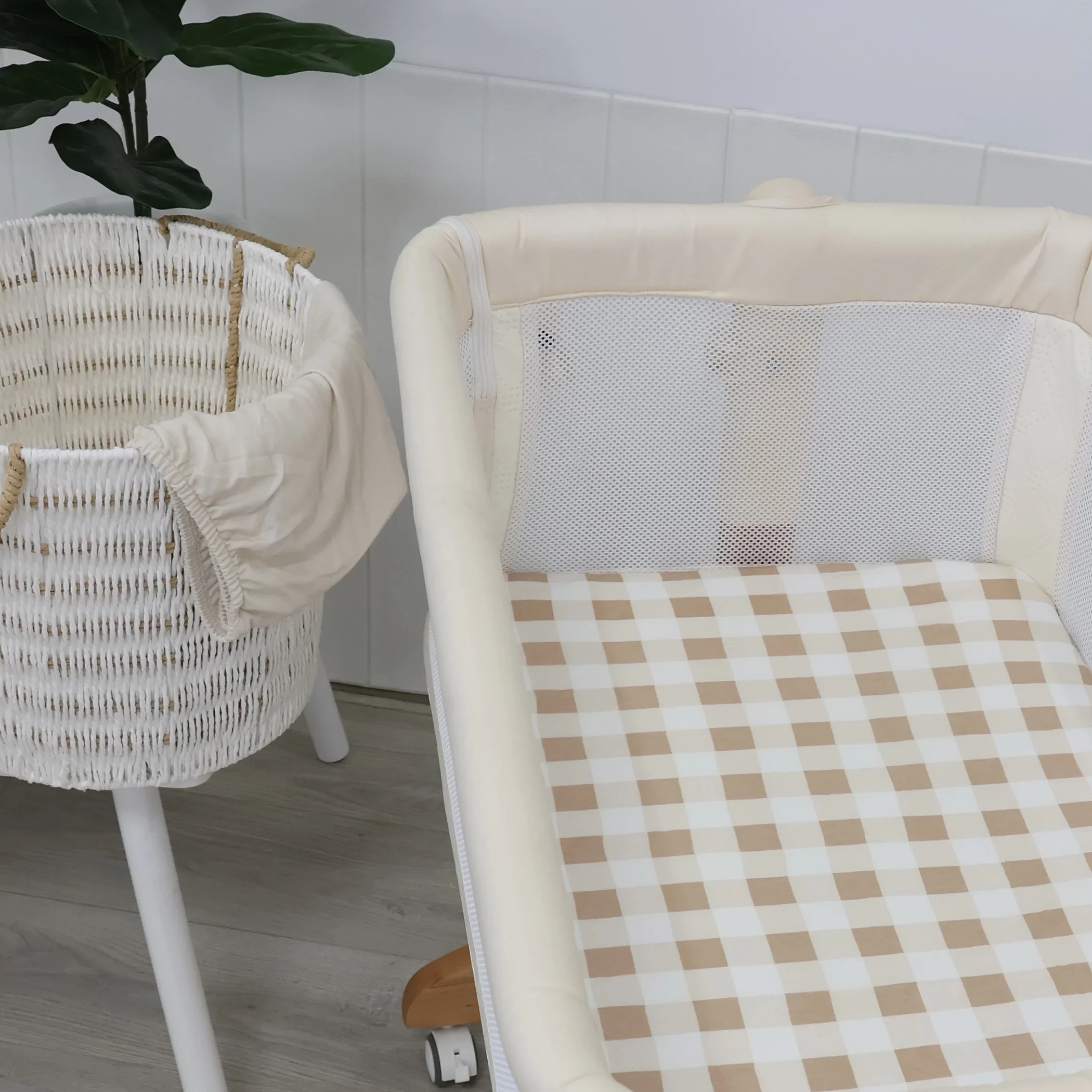 A nursery setup with bubba blue bassinet sheets shown in beige checks
