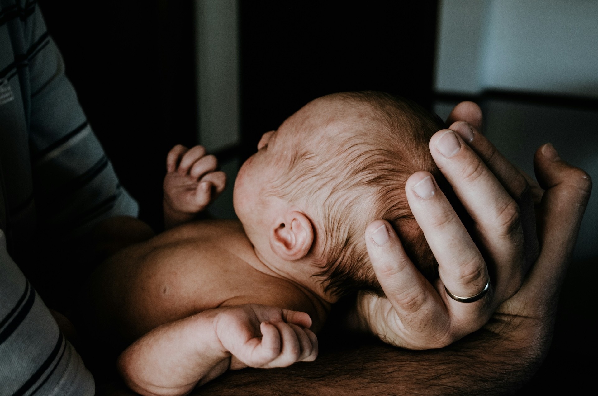 an australian parent holding a newborn baby