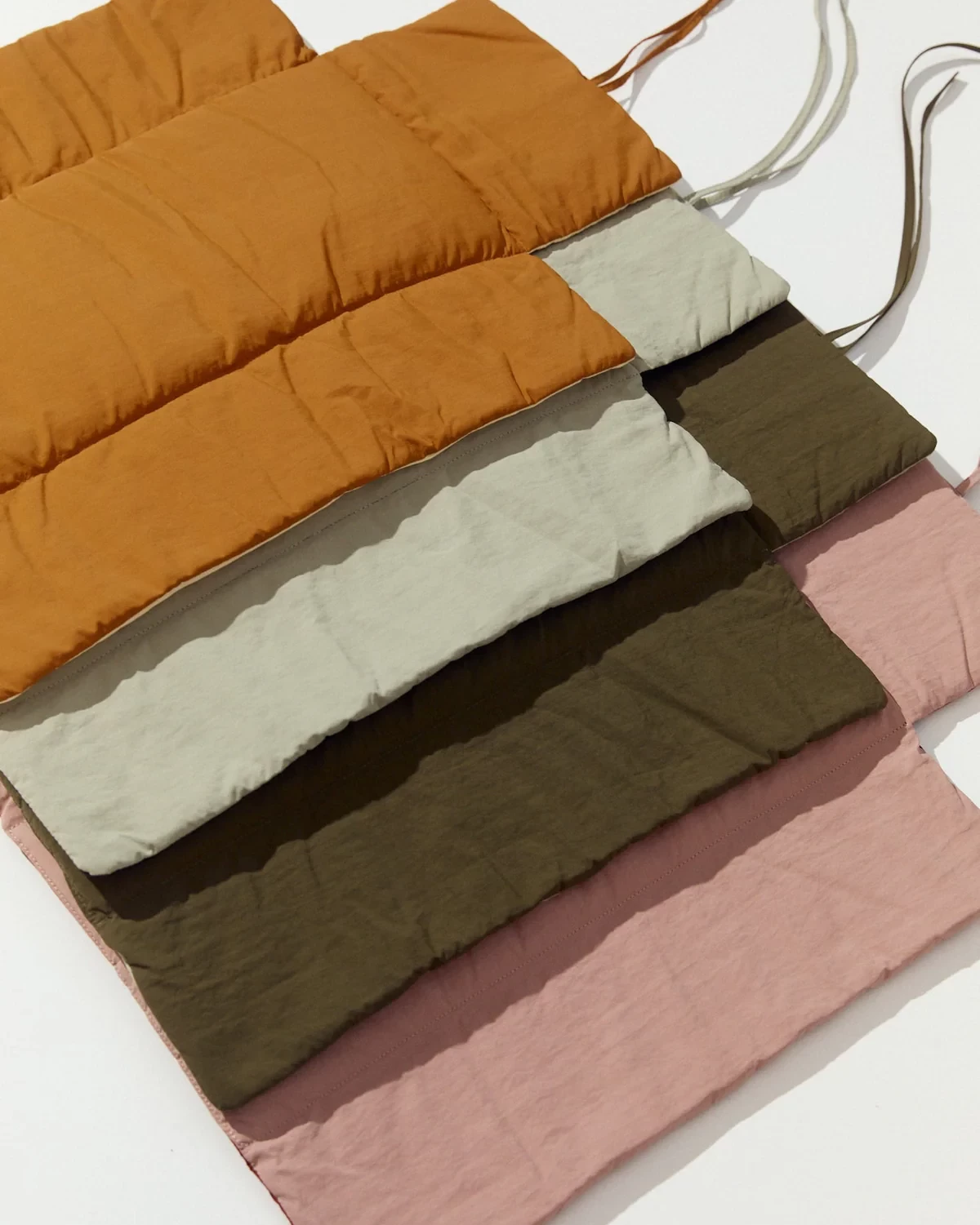 Phile portable changing mats in four colours layered on top of each other